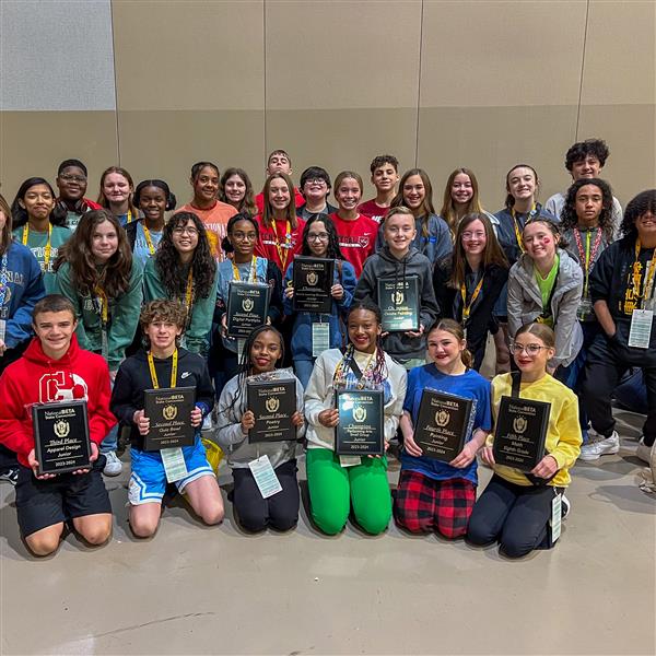  A group of young students holding awards and smiling in a group photo at the Beta Club Convention.