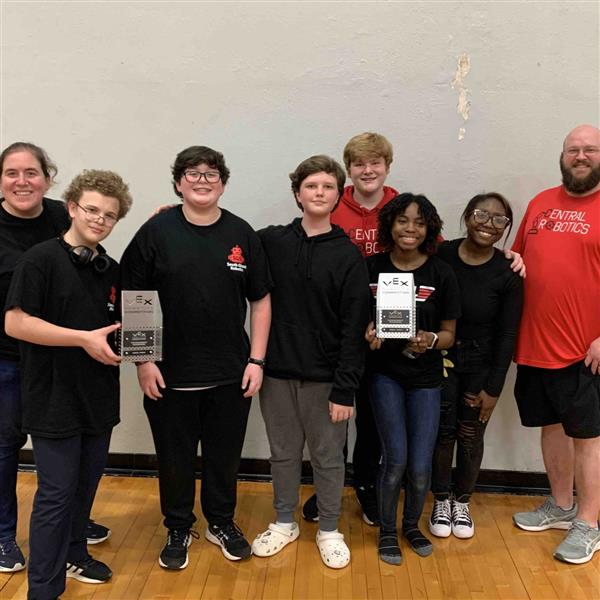 A robotics team celebrates with awards.