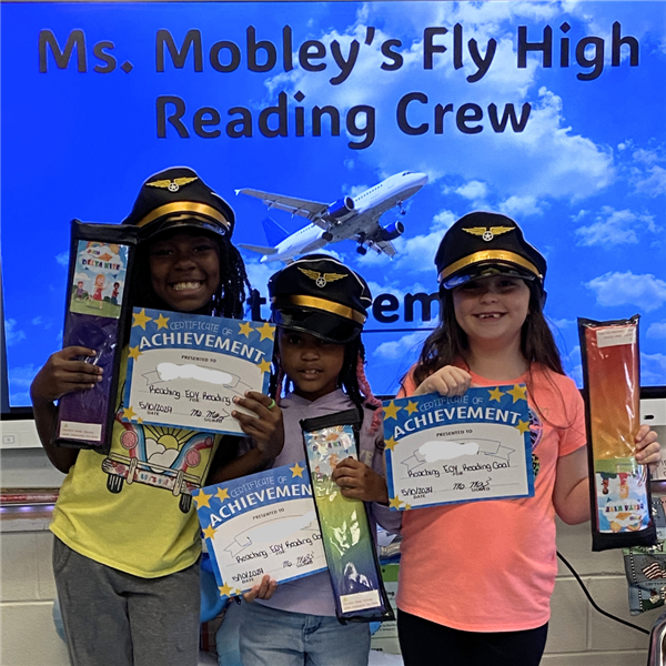  Three students pose with pilots hats and a certificate of achievement 